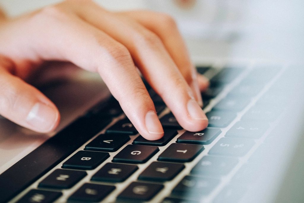 Close view of hands typing on a keyboard